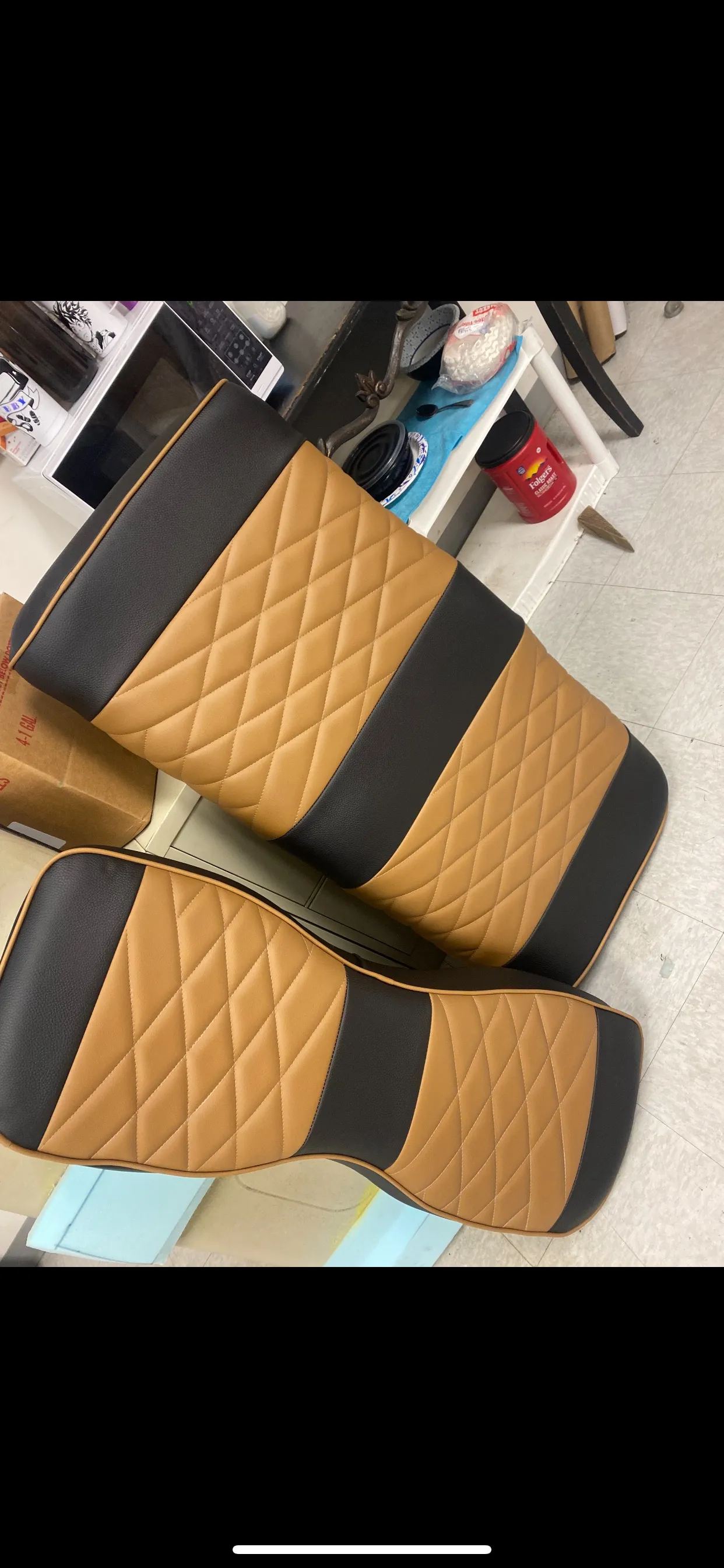 Two-tone tan and black diamond-stitched seat covers in shop