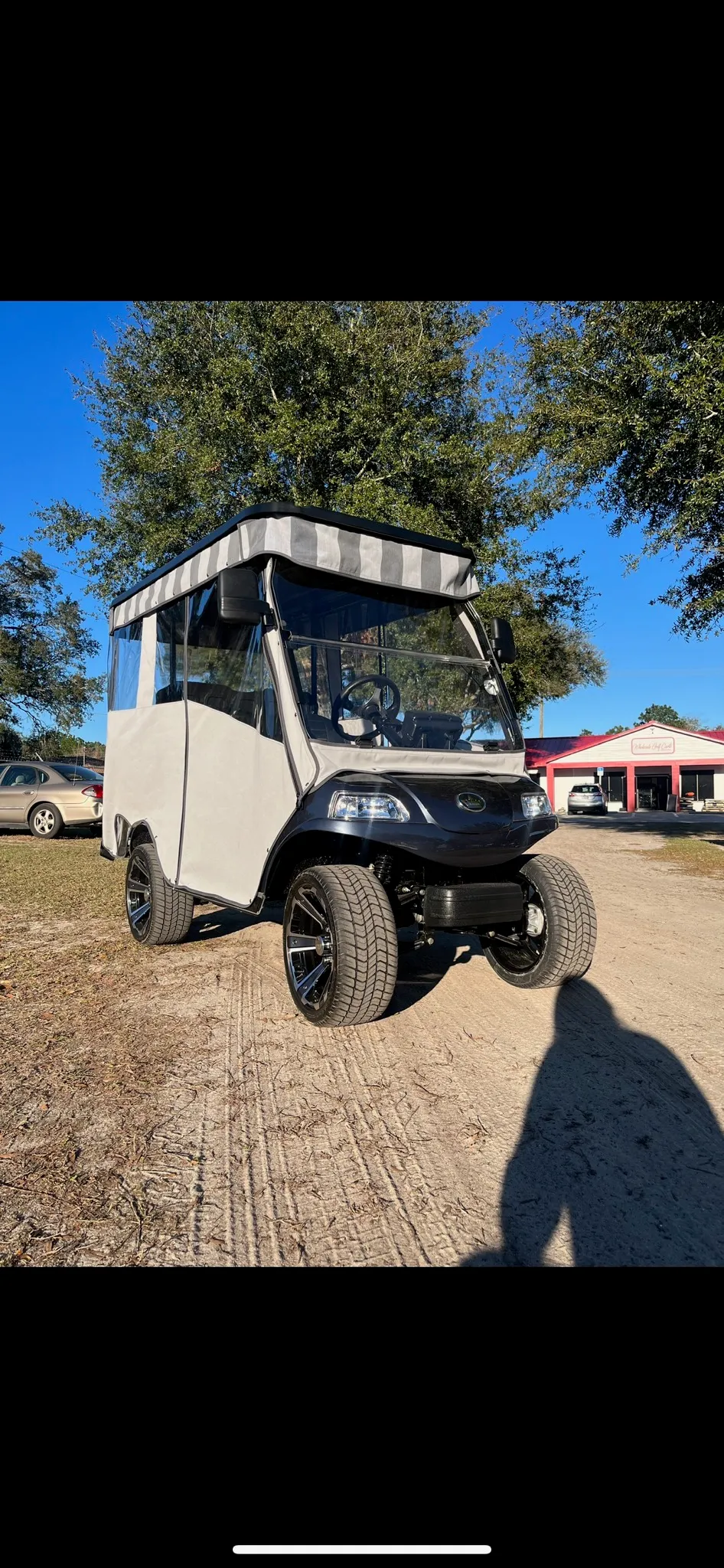 Gray full enclosure with striped top on lifted cart