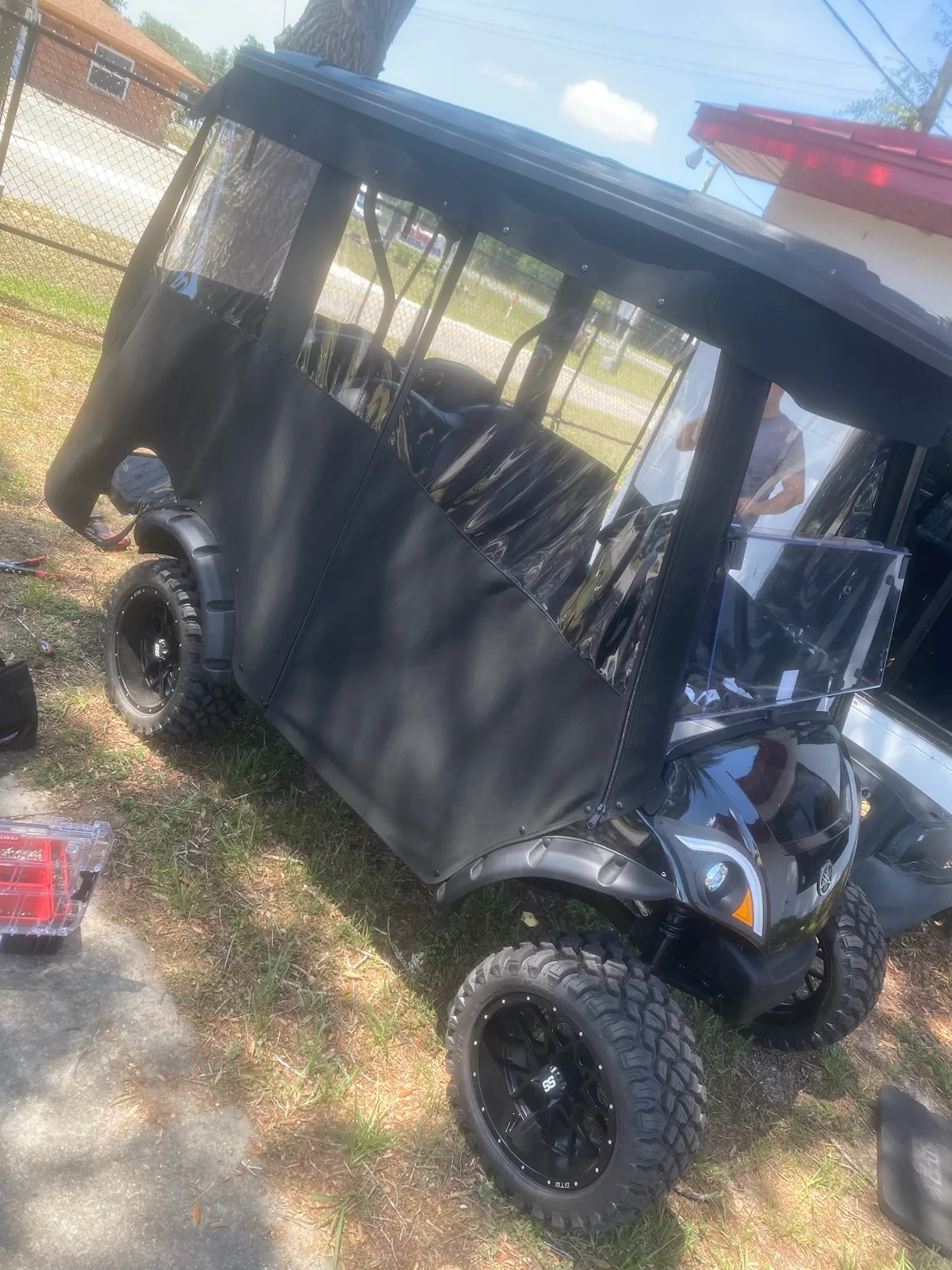Black full enclosure with clear vinyl windows on lifted cart