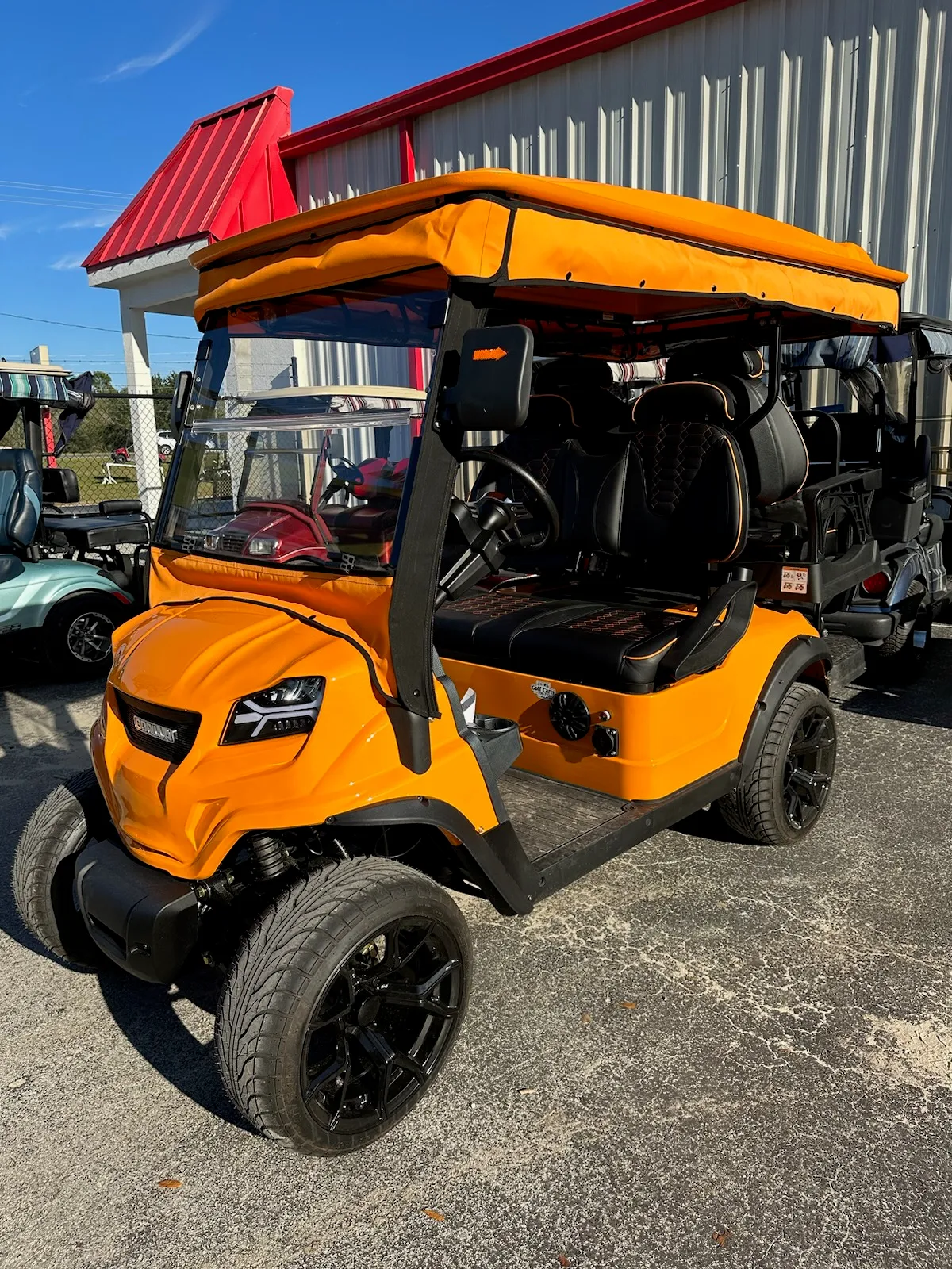 Orange canvas canopy top on matching custom golf cart
