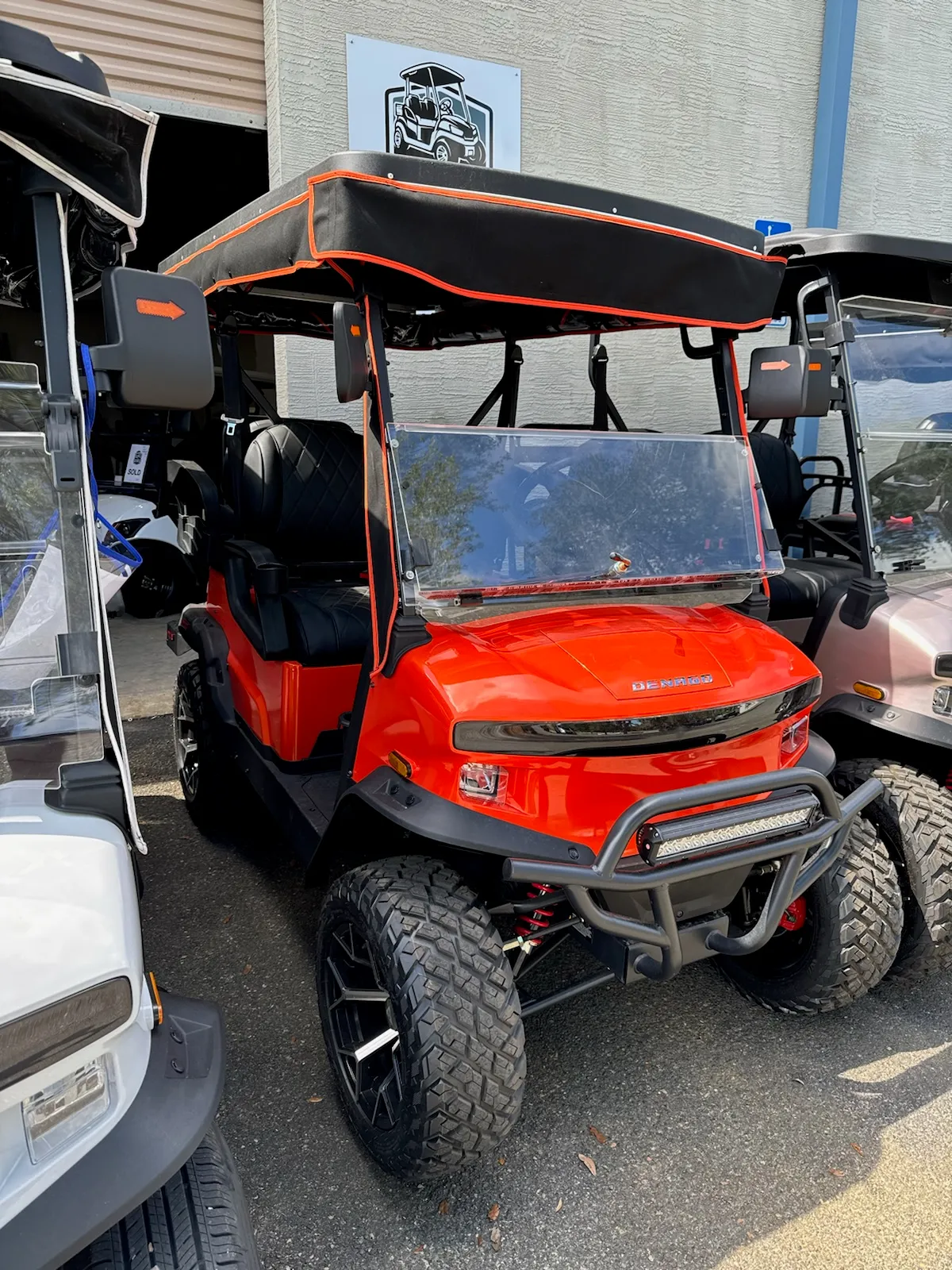Orange lifted cart with orange-piped black canopy top